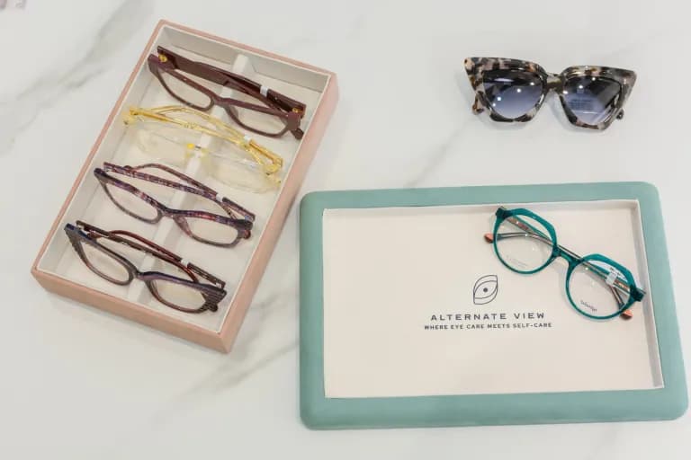 Eyewear collection in branded storage boxes and on display with sunglasses